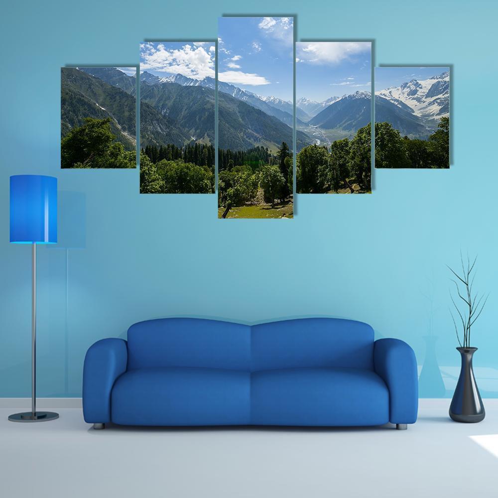 Snow-capped Mountain Range with Forest Canvas Wall Art in white, green and blue, 5 panel Star layout hung on a wall