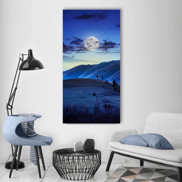 Moonlit Mountains with Lone Cabin Vertical Canvas Wall Art in white, blue and navy, single vertical panel hung on a wall