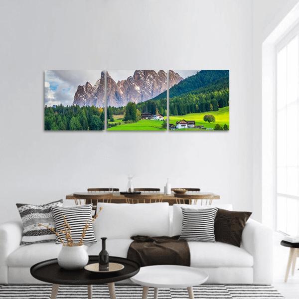 Alpine Village with Snow-capped Peaks Panoramic Canvas Wall Art in gray, green and blue, hung on a wall