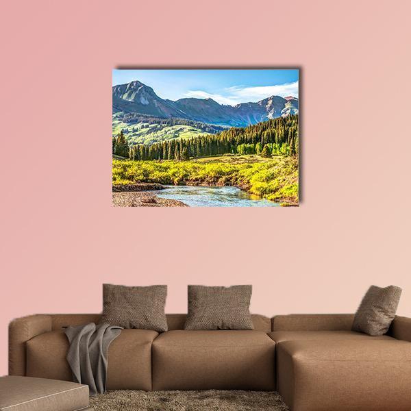 Slate River and Snow-capped Mountains Canvas Wall Art in yellow, green and blue, single panel hung on a wall