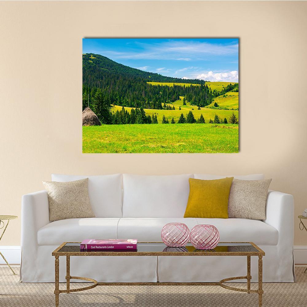 Haystack in Mountain Meadow Canvas Wall Art in yellow, green and blue, single panel hung on a wall