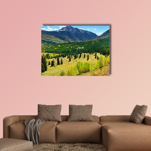 Snow-capped Mountain and Fall Forest Canvas Wall Art in yellow, green and blue, single panel hung on a wall