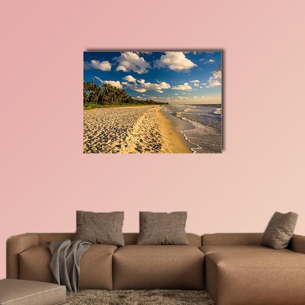 Tropical Shoreline with Palms and Footprints Canvas Wall Art in beige, yellow and blue, single panel hung on a wall