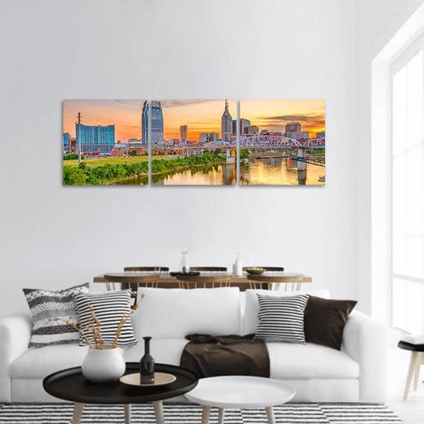 Nashville Skyline at Golden Hour Panoramic Canvas Wall Art in orange, yellow and blue, hung on a wall
