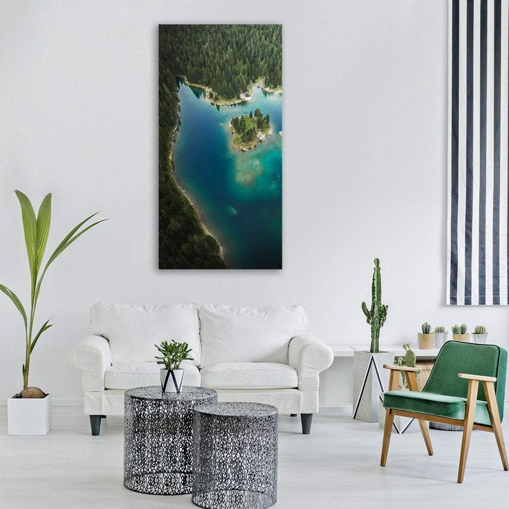 Tree-covered Island on Turquoise Lake Vertical Canvas Wall Art in green and blue, single vertical panel hung on a wall