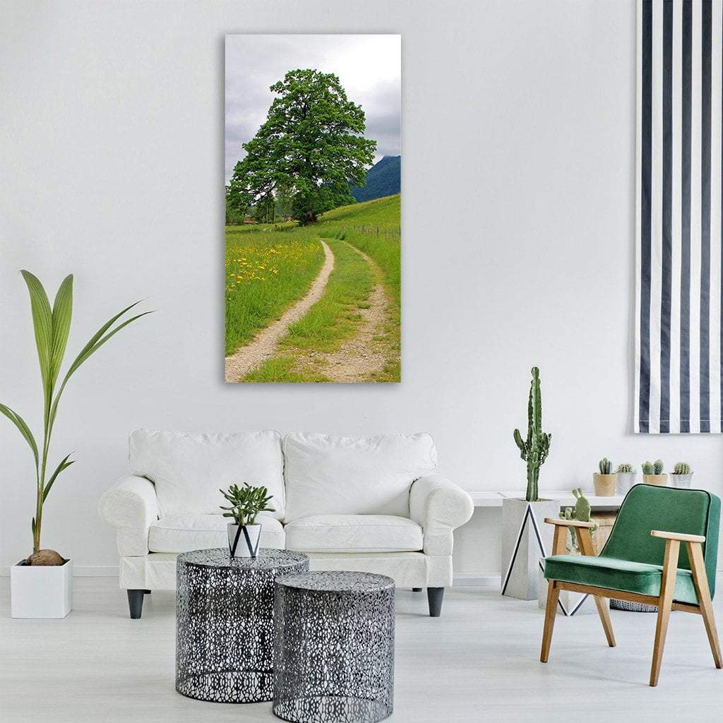 Dirt Path Through Summer Meadow Vertical Canvas Wall Art in gray, beige and green, single vertical panel hung on a wall