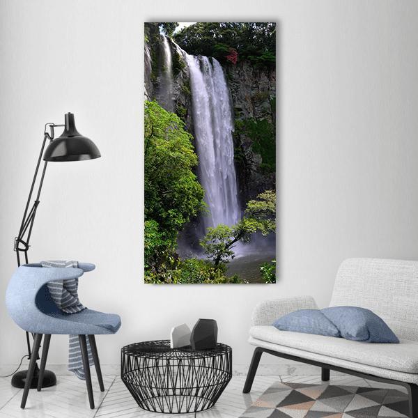 Cascading Waterfall with Lush Greenery Vertical Canvas Wall Art in white, gray and green, single vertical panel hung on a wall