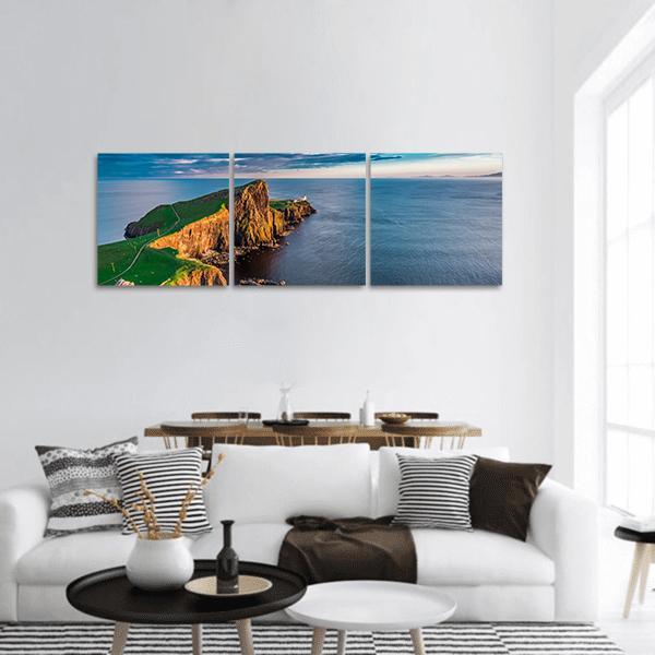 Neist Point Lighthouse at Golden Hour Panoramic Canvas Wall Art in gold, green and blue, hung on a wall