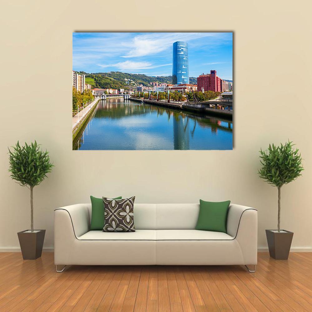 Riverside Embankment with Blue Skyscraper Canvas Wall Art in green and blue, single panel hung on a wall