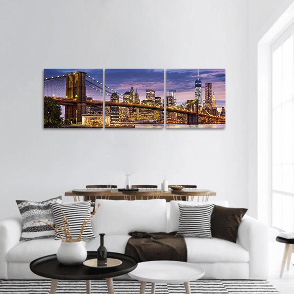 Brooklyn Bridge and Manhattan Skyline at Twilight Panoramic Canvas Wall Art in gold, blue and purple, hung on a wall