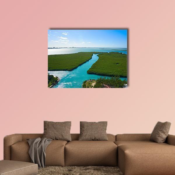 Winding Turquoise River Through Mangroves Canvas Wall Art in green and blue, single panel hung on a wall