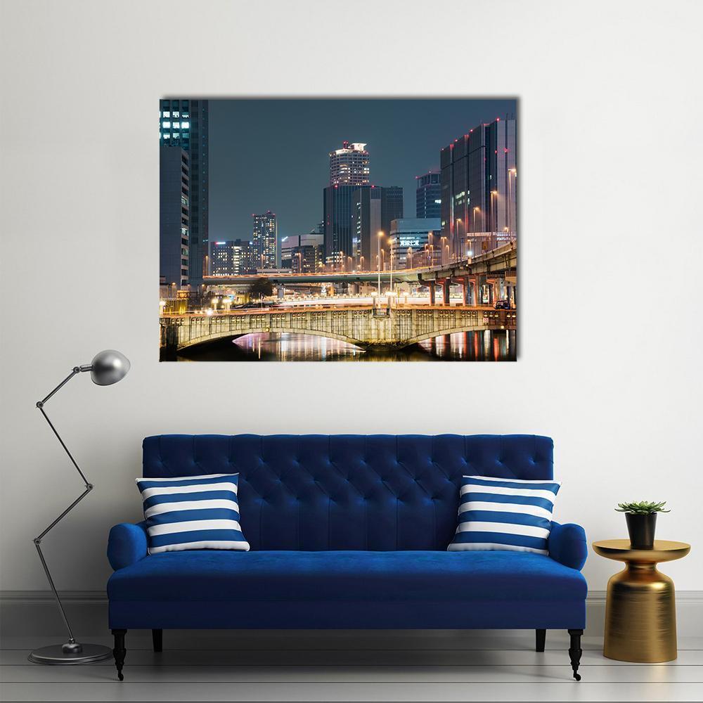 Vibrant Night Skyline of Osaka Canvas Wall Art in black, yellow and blue, single panel hung on a wall