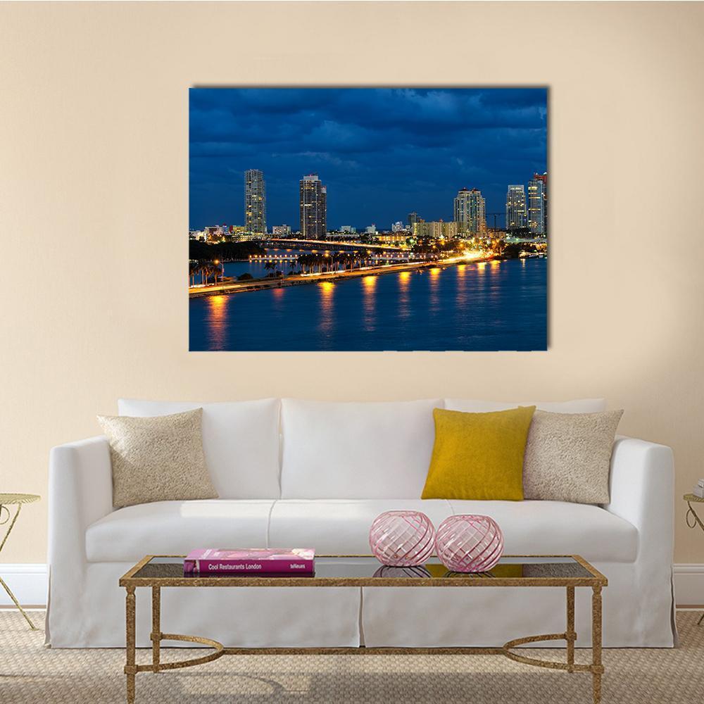 Miami Night Skyline Over Waterfront Canvas Wall Art in yellow, blue and navy, single panel hung on a wall