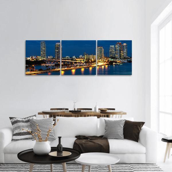 Night Skyline Over Miami Waterfront Panoramic Canvas Wall Art in black, yellow and blue, hung on a wall
