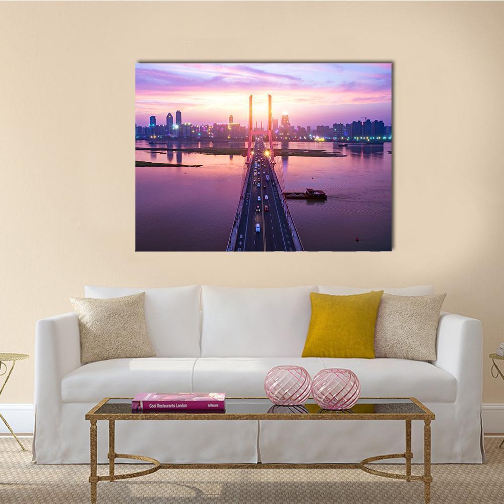 Modern Suspension Bridge at Sunset Canvas Wall Art in orange, blue and purple, single panel hung on a wall