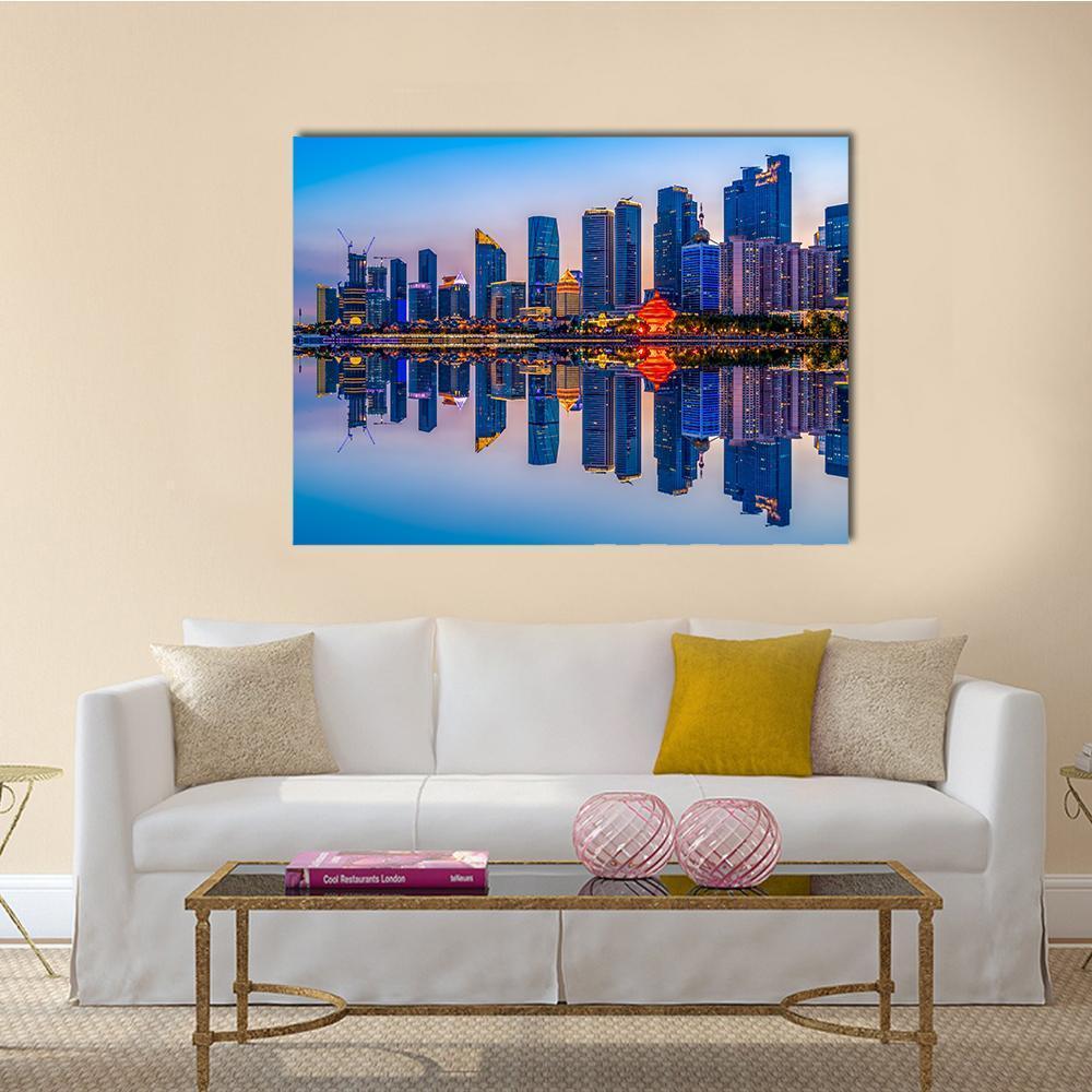 Dusk City Skyline with Orange Dome Reflection Canvas Wall Art in orange and blue, single panel hung on a wall