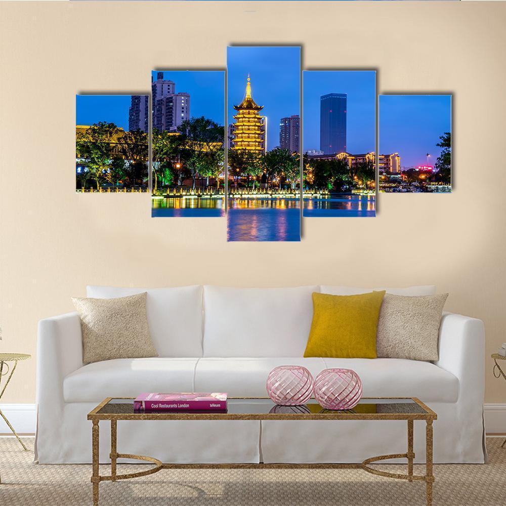 Qingjiangpu Night Skyline with Illuminated Pagoda Canvas Wall Art in gold and blue, 5 panel Star layout hung on a wall
