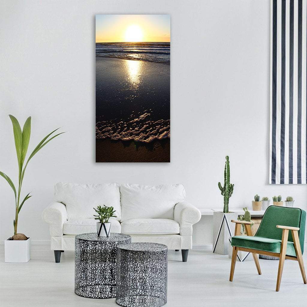 Sunset Reflection on Wet Sand Vertical Canvas Wall Art in black, orange and yellow, single vertical panel hung on a wall