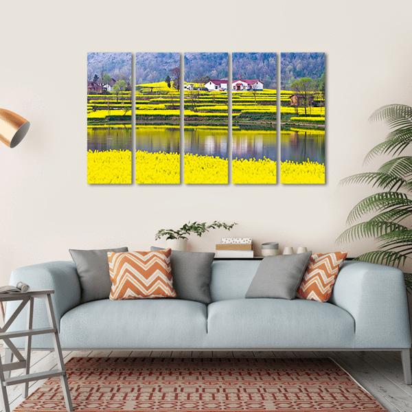 Rural Spring Scenery Canvas Wall Art in yellow, green and blue, hung on a wall