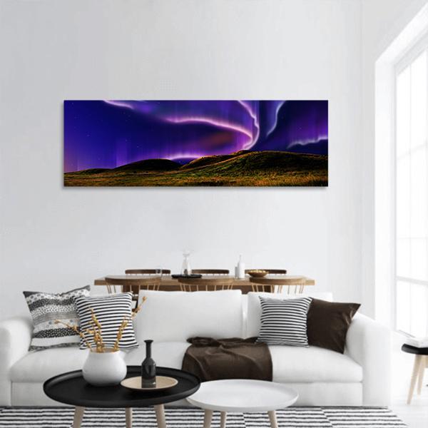 Northern Lights Over Silent Field Panoramic Canvas Wall Art in green, blue and purple, single panel hung on a wall