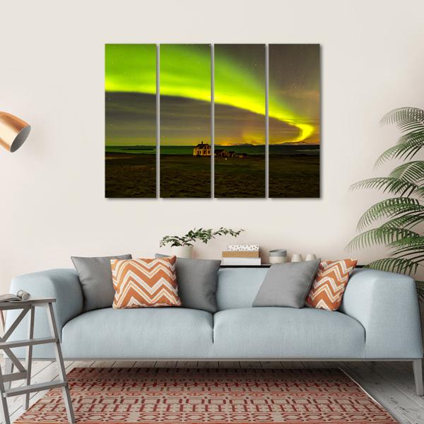 Northern Lights Over Iceland Canvas Wall Art in black, yellow and green, hung on a wall