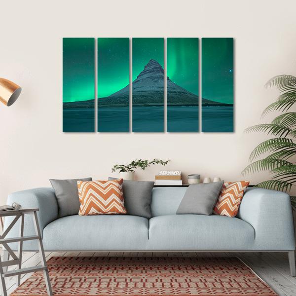 Northern Lights Over Mount Kirkjufell Canvas Wall Art in green and blue, hung on a wall