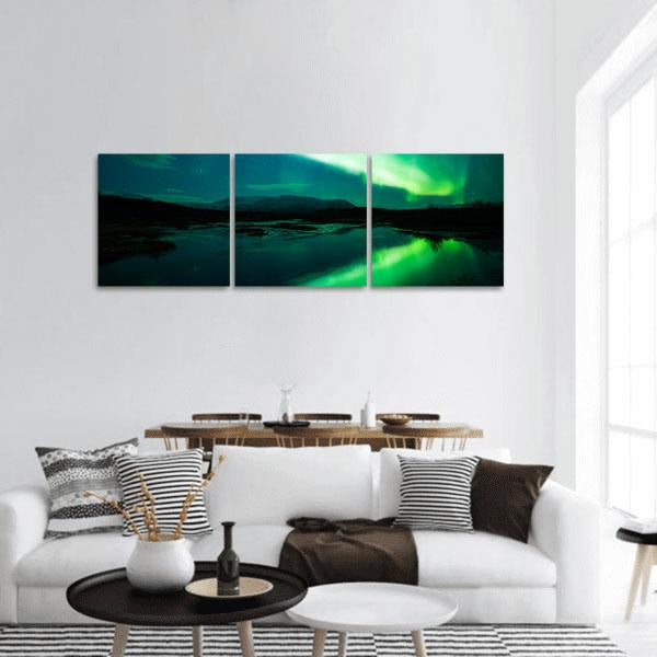 Aurora Borealis Over Mountain Lake Panoramic Canvas Wall Art in black, green and blue, single panel hung on a wall