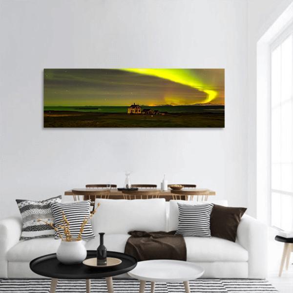 Northern Lights Over Iceland Panoramic Canvas Wall Art in black, yellow and green, single panel hung on a wall
