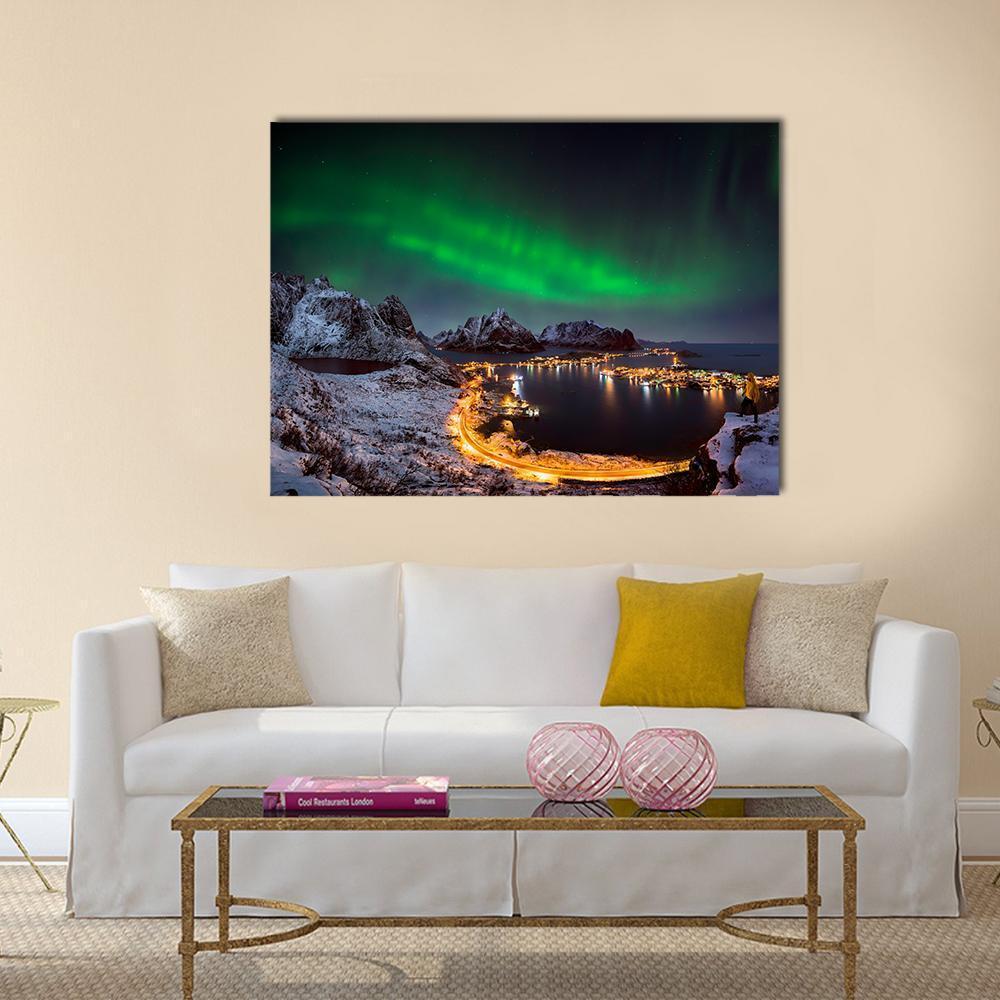 Northern Lights Over Reine Canvas Wall Art in black, green and blue, single panel hung on a wall