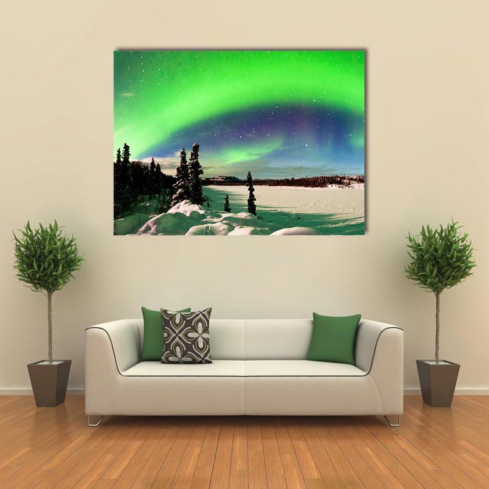 Northern Lights Over Snowy Landscape Canvas Wall Art in white, green and blue, single panel hung on a wall