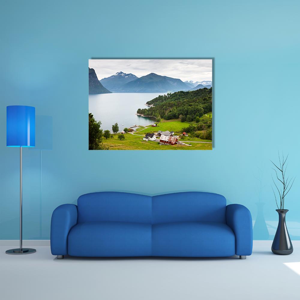 Norwegian Countryside with Red Farmhouses Canvas Wall Art in green and blue, single panel hung on a wall