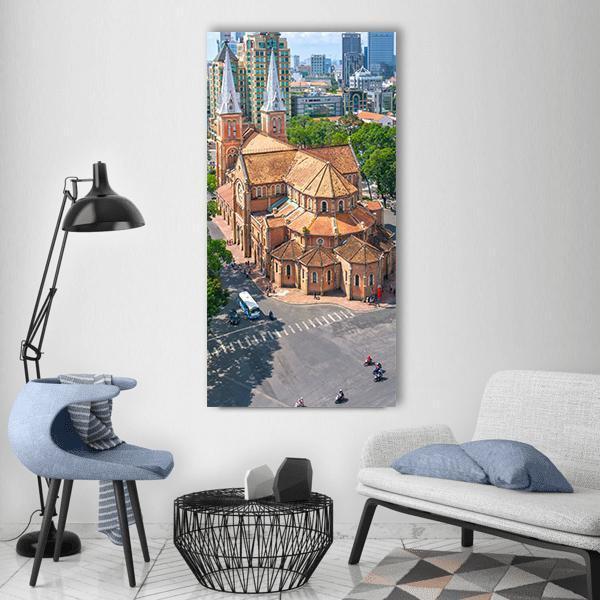 Saigon Notre-dame Basilica Aerial View Vertical Canvas Wall Art in gray, orange and blue, single vertical panel hung on a wall