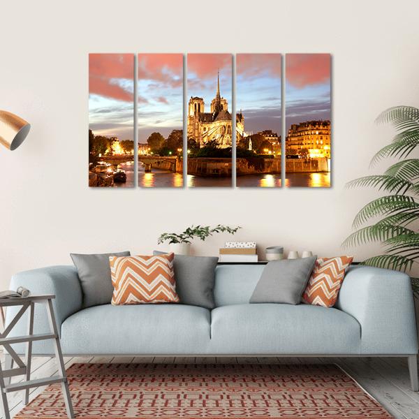 Notre Dame Cathedral at Dusk Canvas Wall Art in orange, yellow and blue, hung on a wall