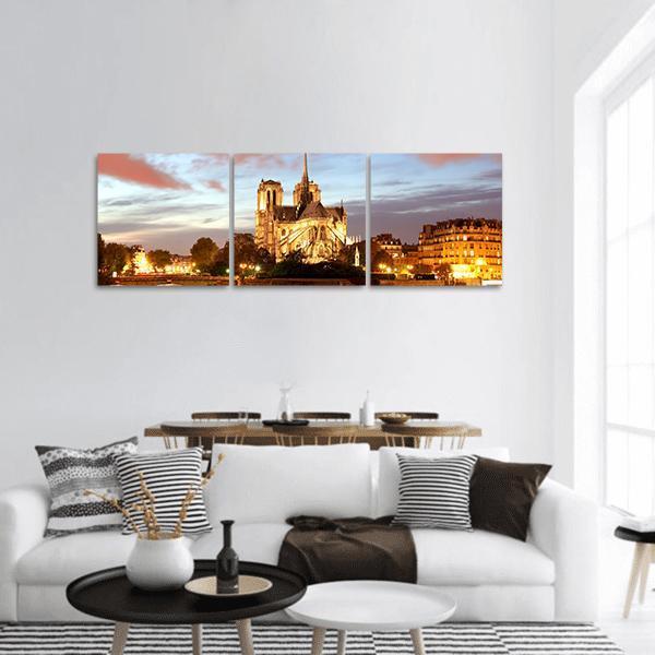 Notre Dame Cathedral at Dusk Panoramic Canvas Wall Art in gold, orange and blue, hung on a wall