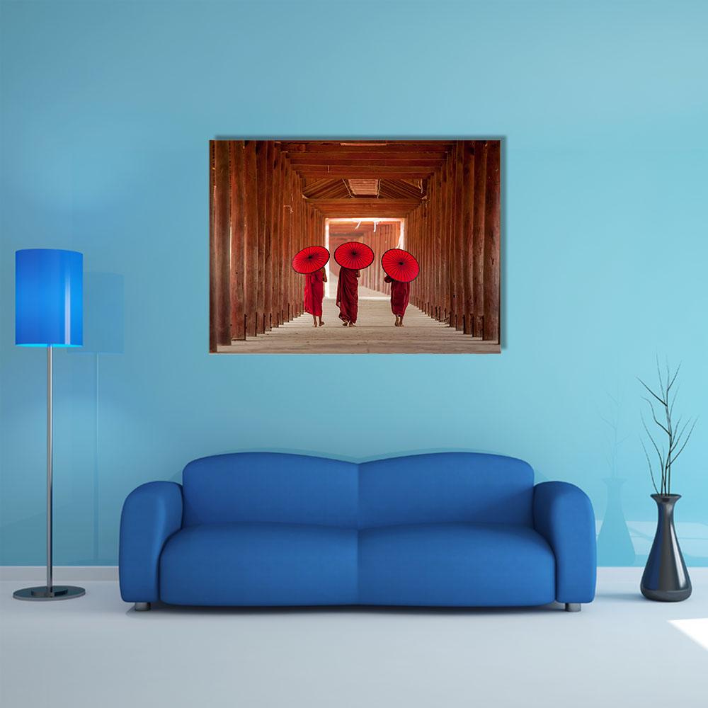 Three Novice Monks in Wooden Corridor Canvas Wall Art in brown and red, single panel hung on a wall