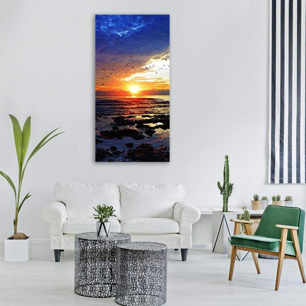 Ocean Beach at Sunset Vertical Canvas Wall Art in orange, yellow and blue, single vertical panel hung on a wall