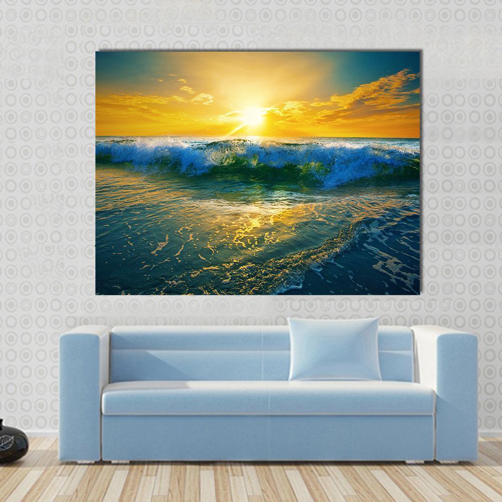 Ocean Waves at Sunrise Canvas Wall Art in orange, yellow and blue, single panel hung on a wall