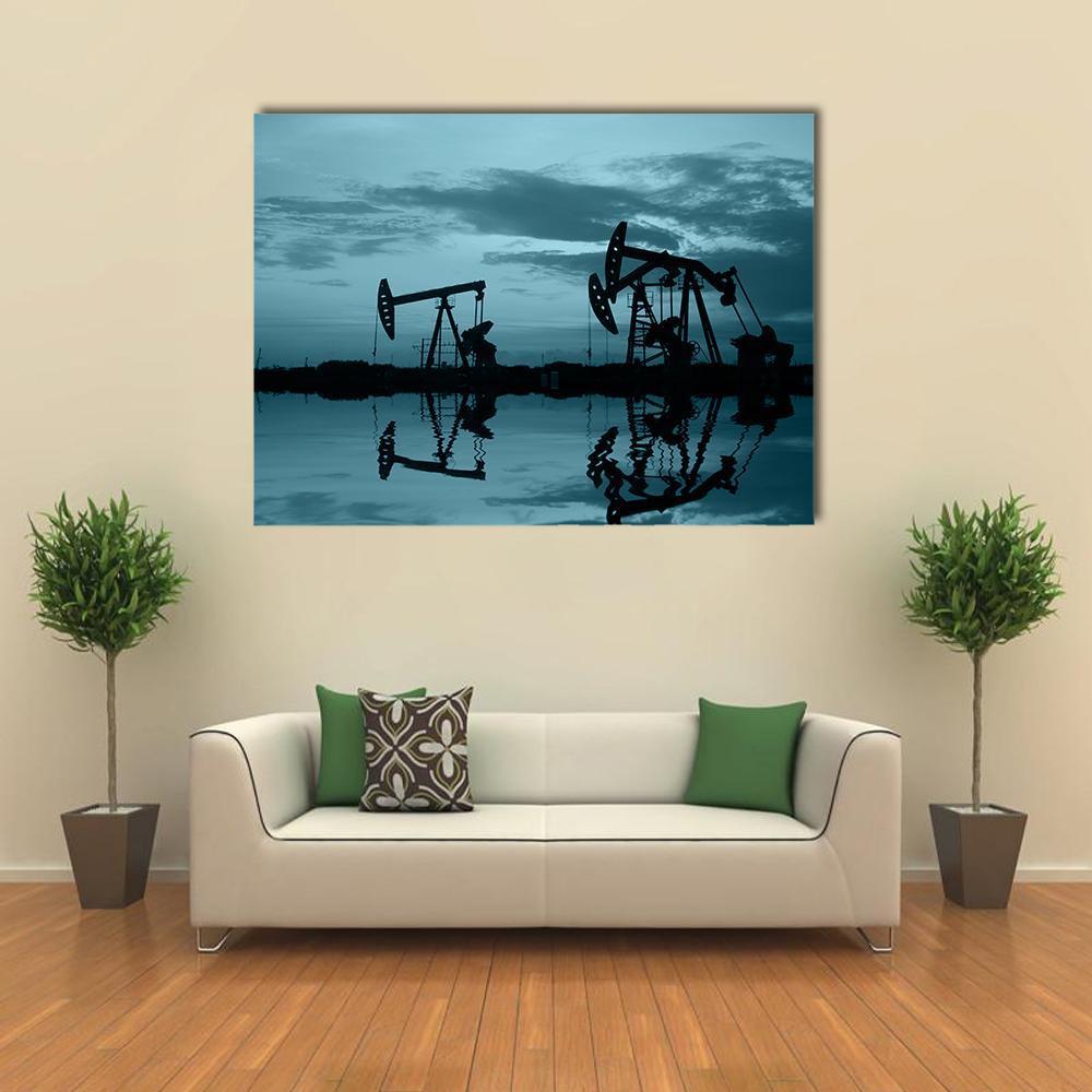 Silhouetted Oil Pumpjacks at Dusk with Reflections Canvas Wall Art in black and blue, single panel hung on a wall