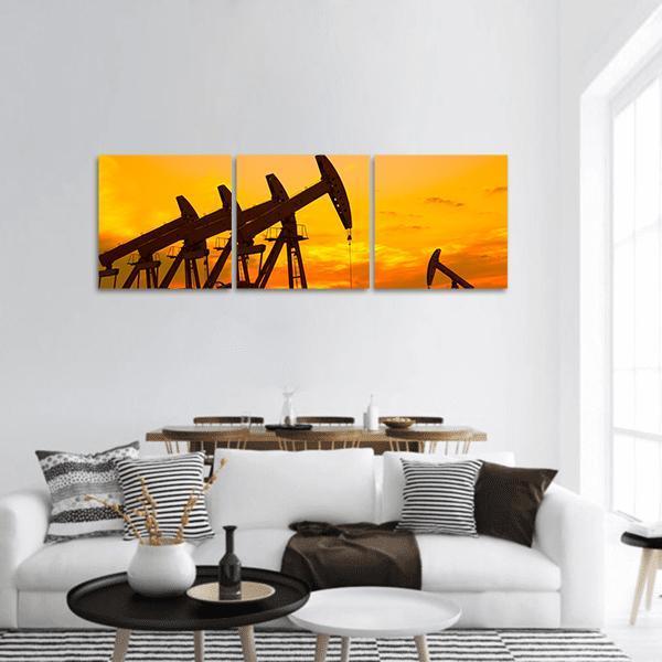 Pump Jacks at Golden Sunset Panoramic Canvas Wall Art in black, orange and yellow, hung on a wall