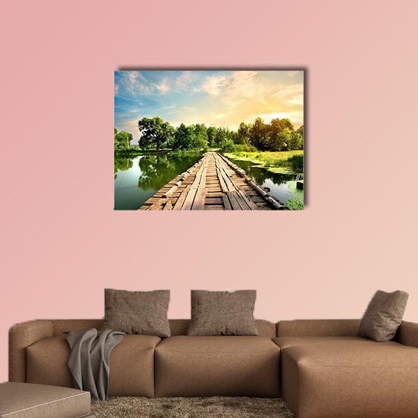 Weathered Wooden Bridge at Sunset Canvas Wall Art in brown, orange and green, single panel hung on a wall