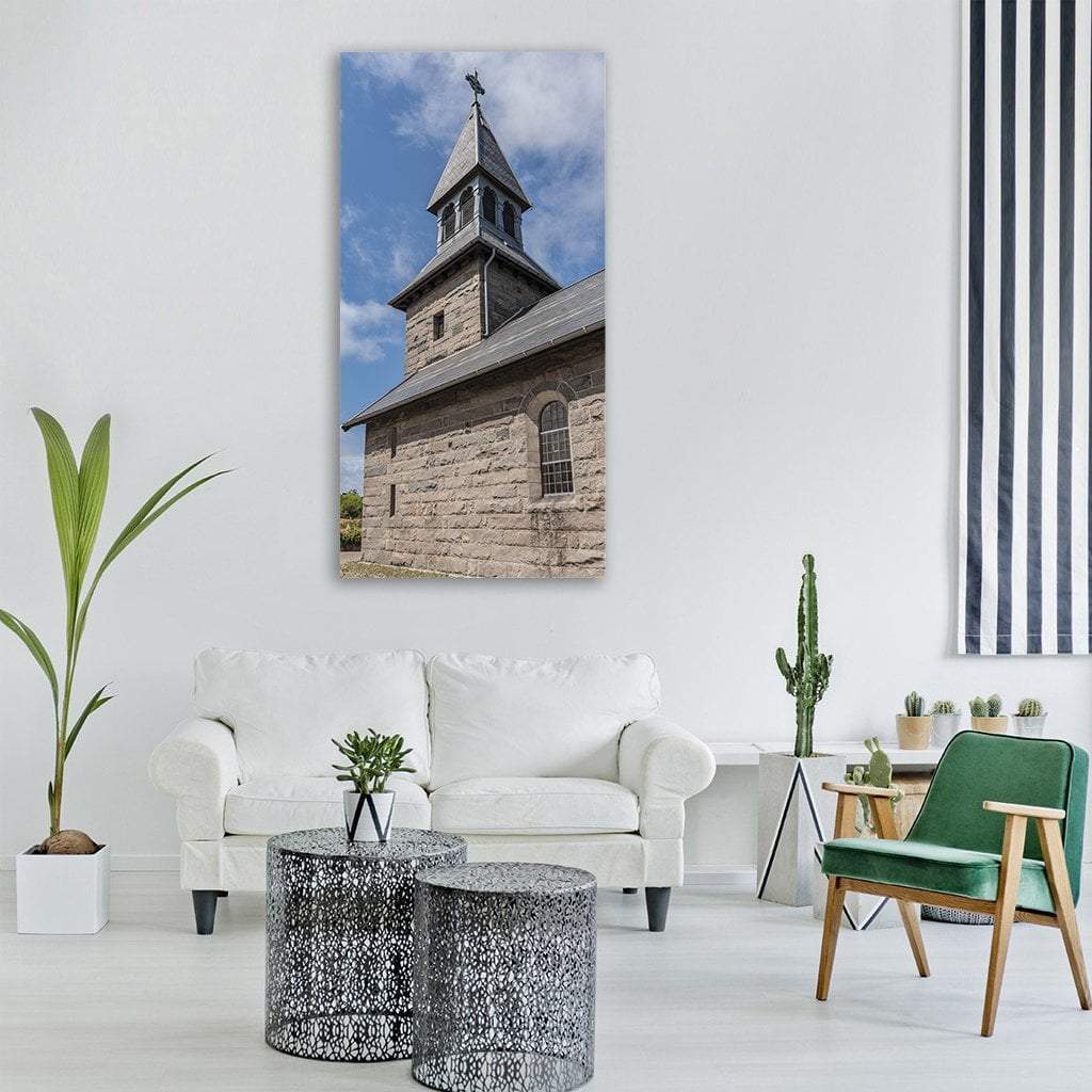 Weathered Stone Church Steeple with Iron Cross Vertical Canvas Wall Art in gray, beige and blue, single vertical panel hung on a wall