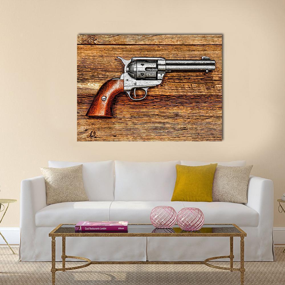 Vintage Revolver on Wood Surface Canvas Wall Art in gray, brown and silver, single panel hung on a wall