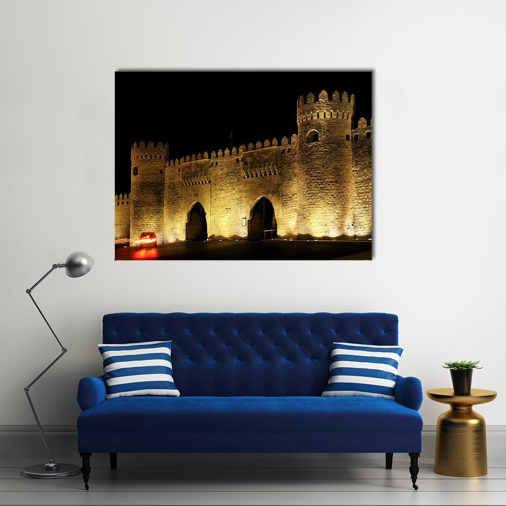Illuminated Old Town Gate at Night Canvas Wall Art in black, gold and yellow, single panel hung on a wall