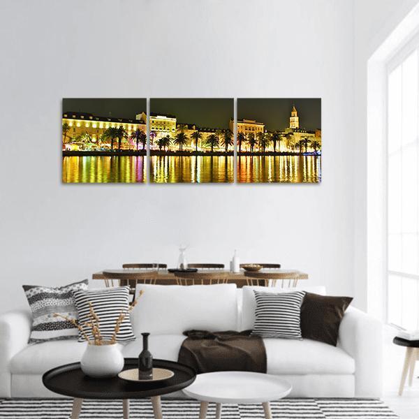 Old Town Croatia Night Reflections Panoramic Canvas Wall Art in black, gold and yellow, hung on a wall
