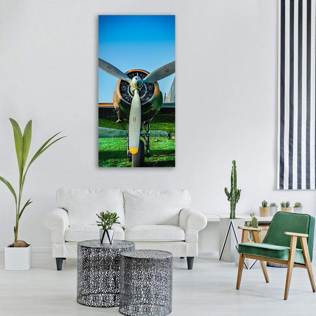 Vintage Airplane Propeller Close-up Vertical Canvas Wall Art in silver, green and blue, single vertical panel hung on a wall