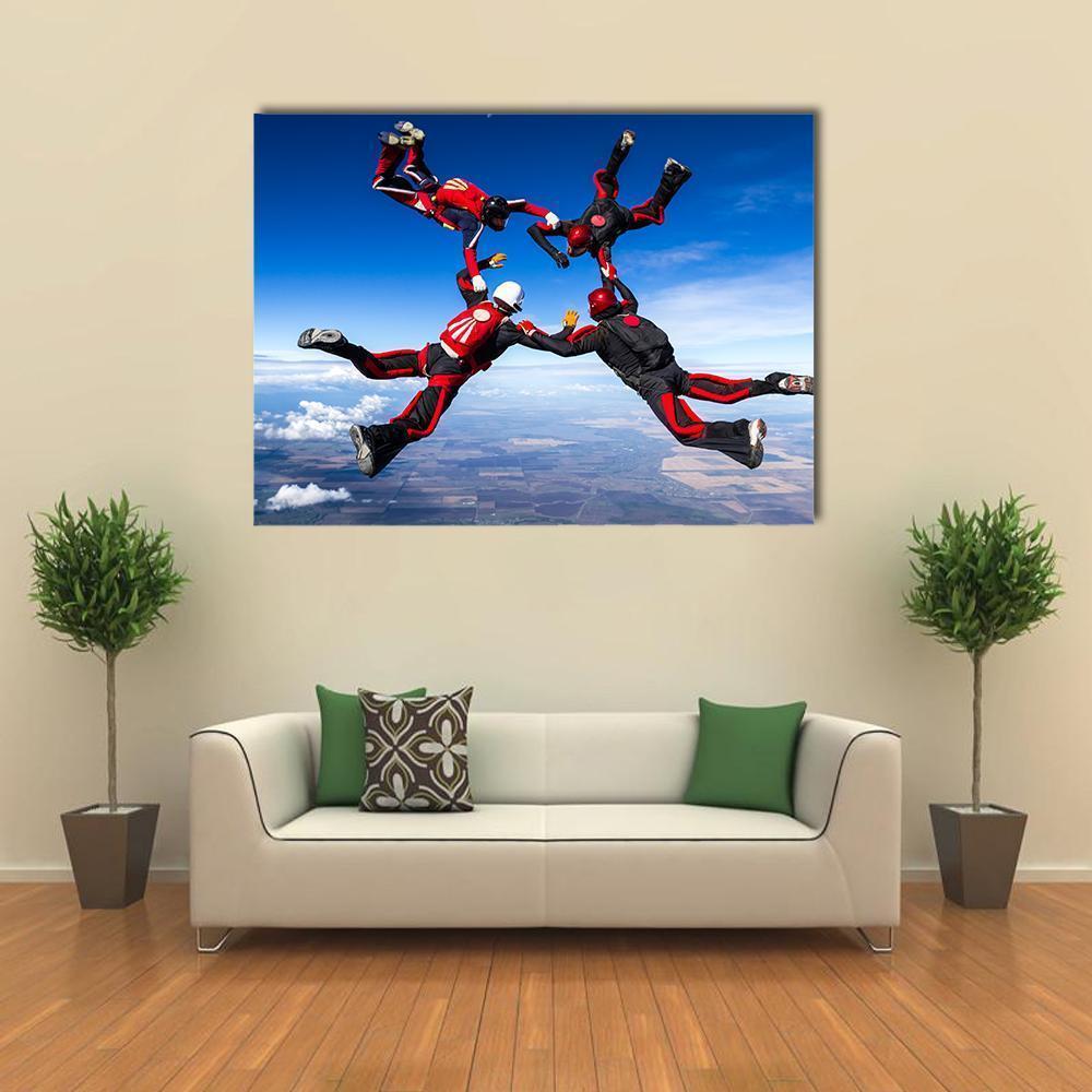 Four Skydivers in Circle Formation Canvas Wall Art in black, red and blue, single panel hung on a wall