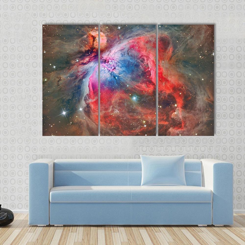 Orion Nebula Canvas Wall Art in black, red and blue, 3 panel horizontal set hung on a wall