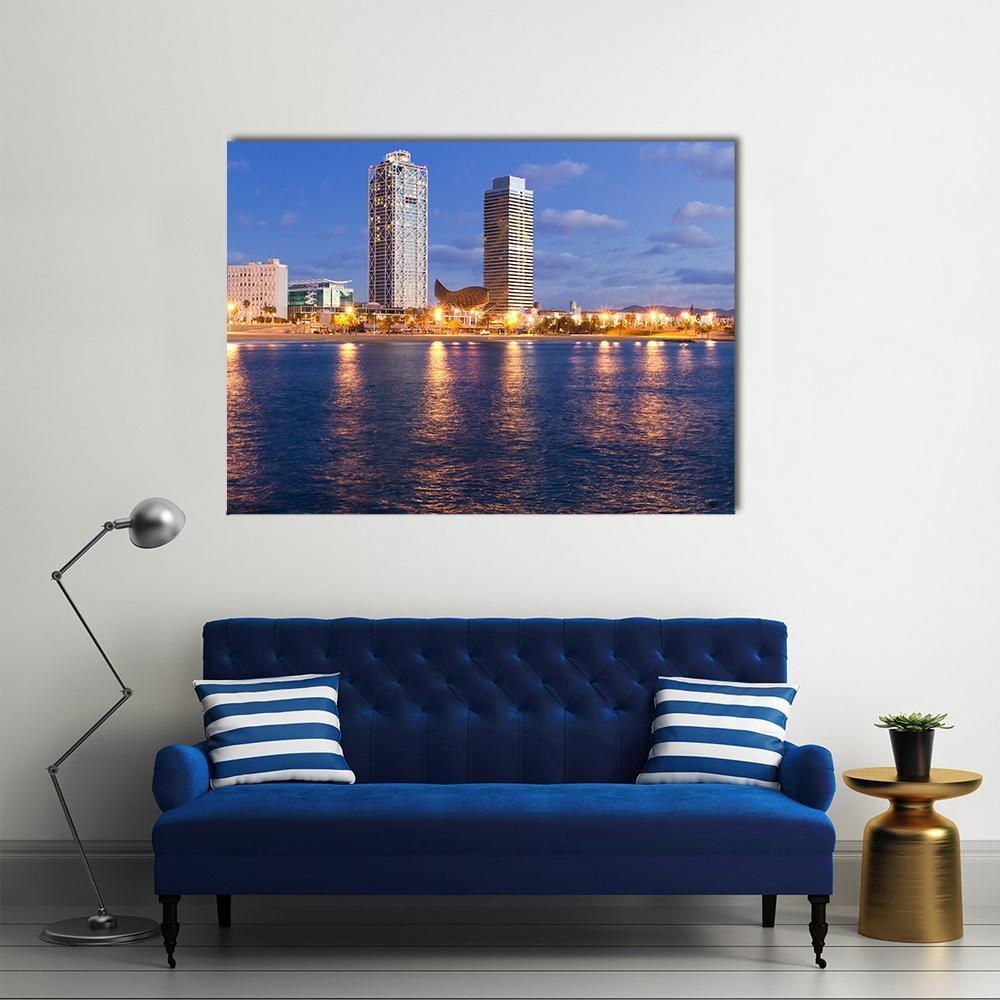 Barcelona Skyline at Twilight Canvas Wall Art in yellow, blue and navy, single panel hung on a wall