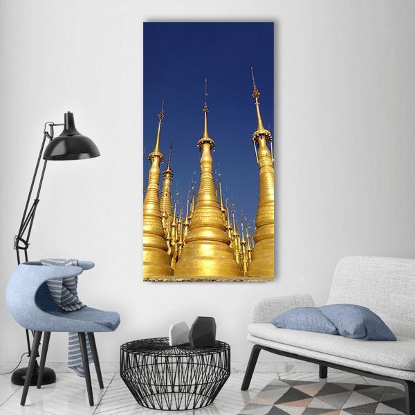 Pagoda Spires in Myanmar Vertical Canvas Wall Art in gold and blue, single vertical panel hung on a wall