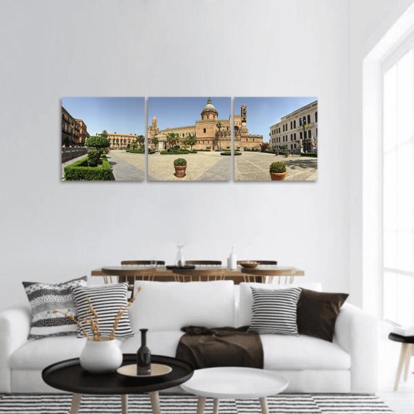Cathedral Courtyard in Sunlit Piazza Panoramic Canvas Wall Art in beige, brown and blue, hung on a wall
